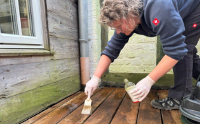 Frau reinigt und ölt ihre Holzterrasse mit Leinos Produkten