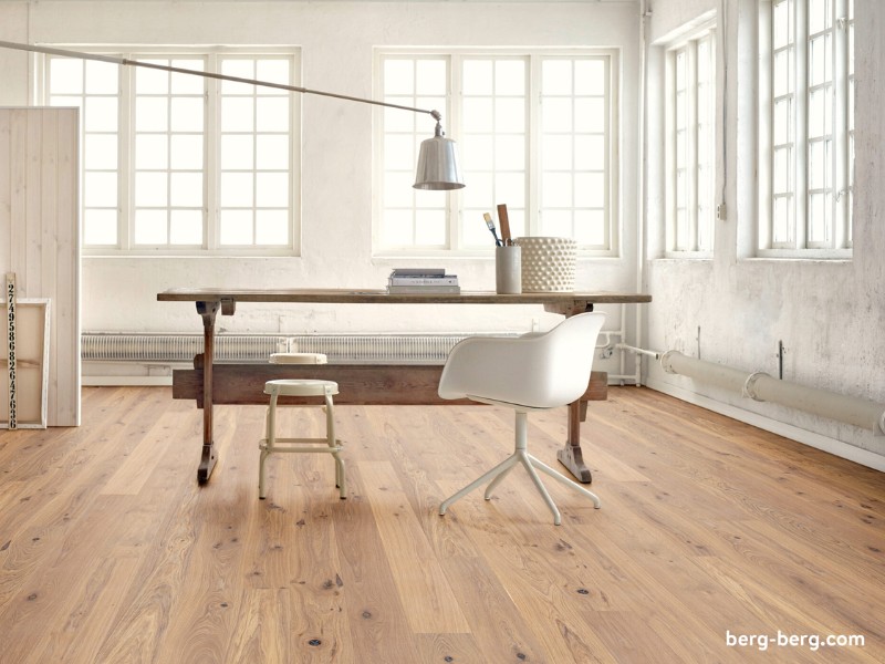 Helles Loft mit reduzierter Einrichtung. Schreibtisch in der Mitte. Edler Holzfußboden von Berg & Berg
